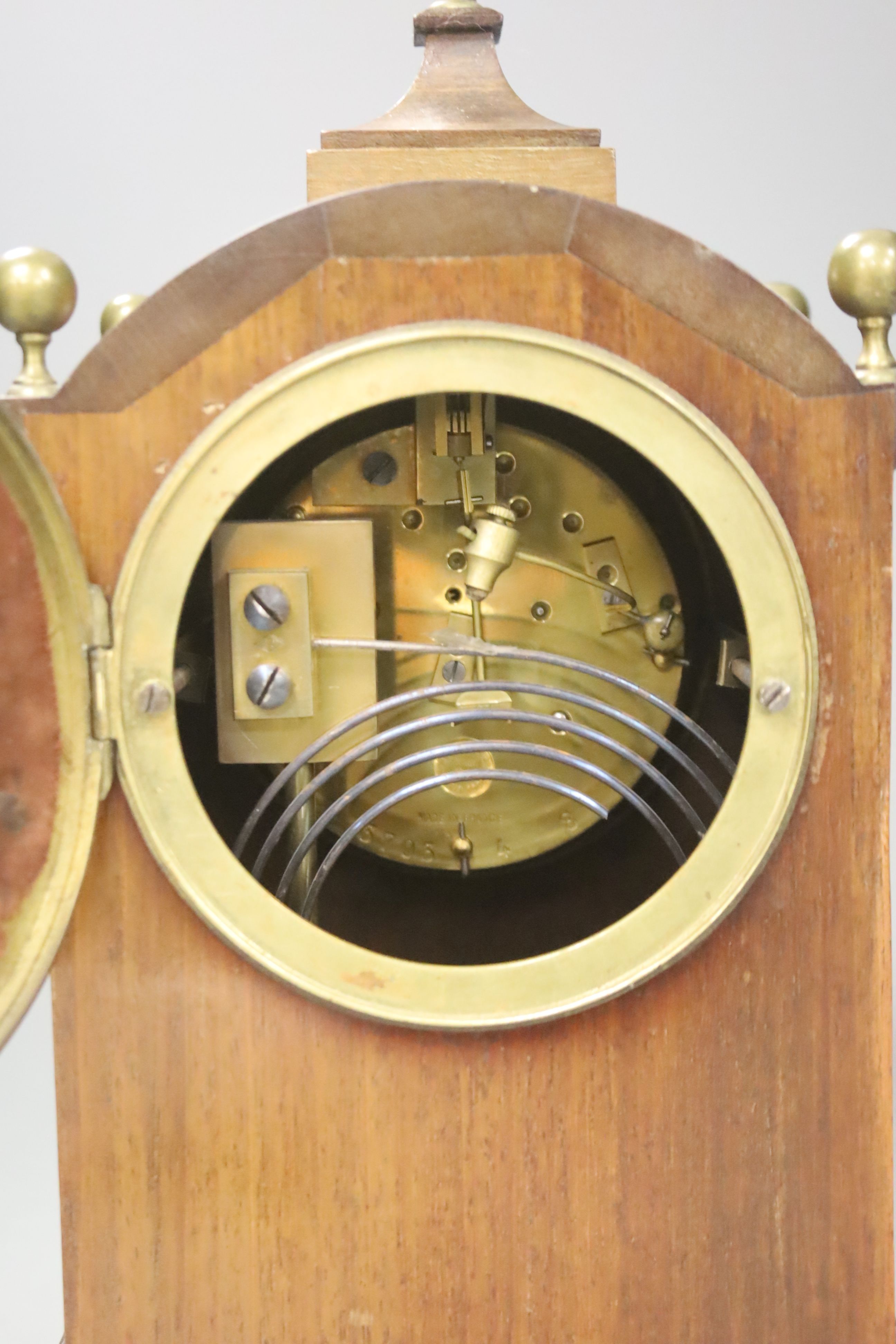 An inlaid mahogany mahogany mantel clock with brass ball finials, height 28cm